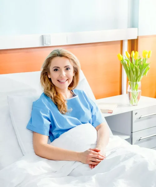 portrait-of-smiling-woman-lying-in-hospital-bed-2023-11-27-05-11-18-utc